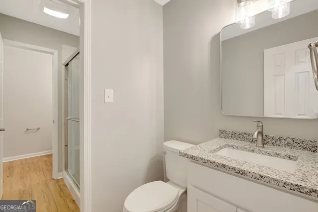 a bathroom with a granite countertop sink toilet and shower