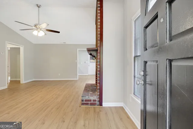 a view of empty room with wooden floor and ceiling fan