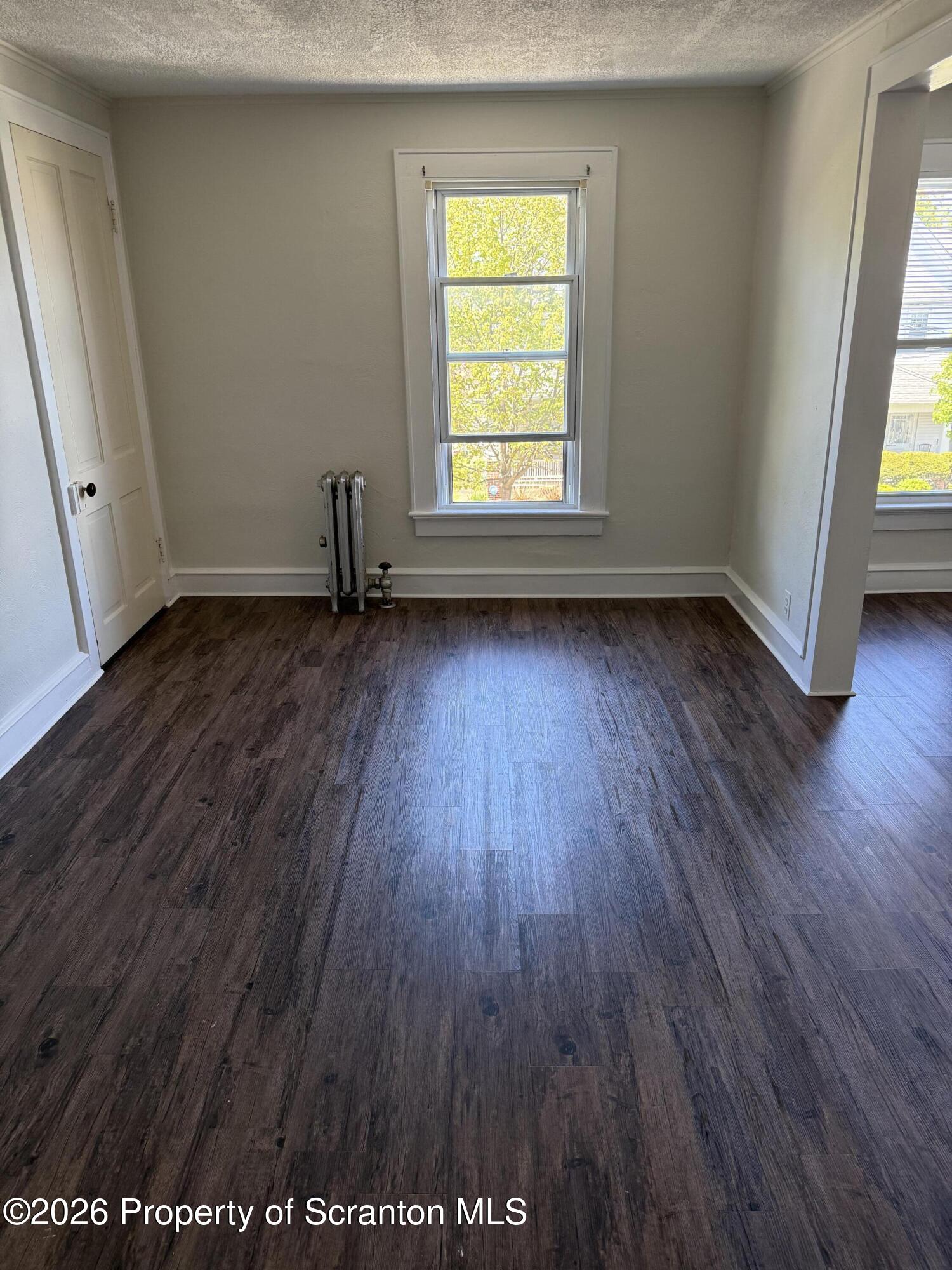 1042 Taylor Avenue, Unit 2 Scranton, PA 18510 - Photo 4 of 14 an empty room with wooden floor and windows