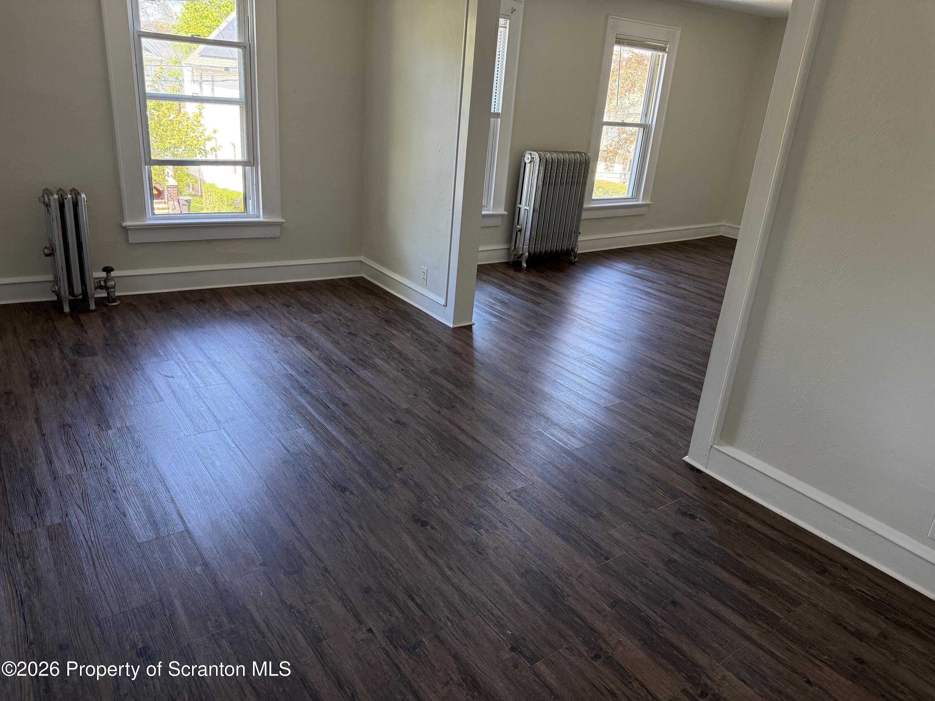 1042 Taylor Avenue, Unit 2 Scranton, PA 18510 - Photo 5 of 14 an empty room with wooden floor and windows