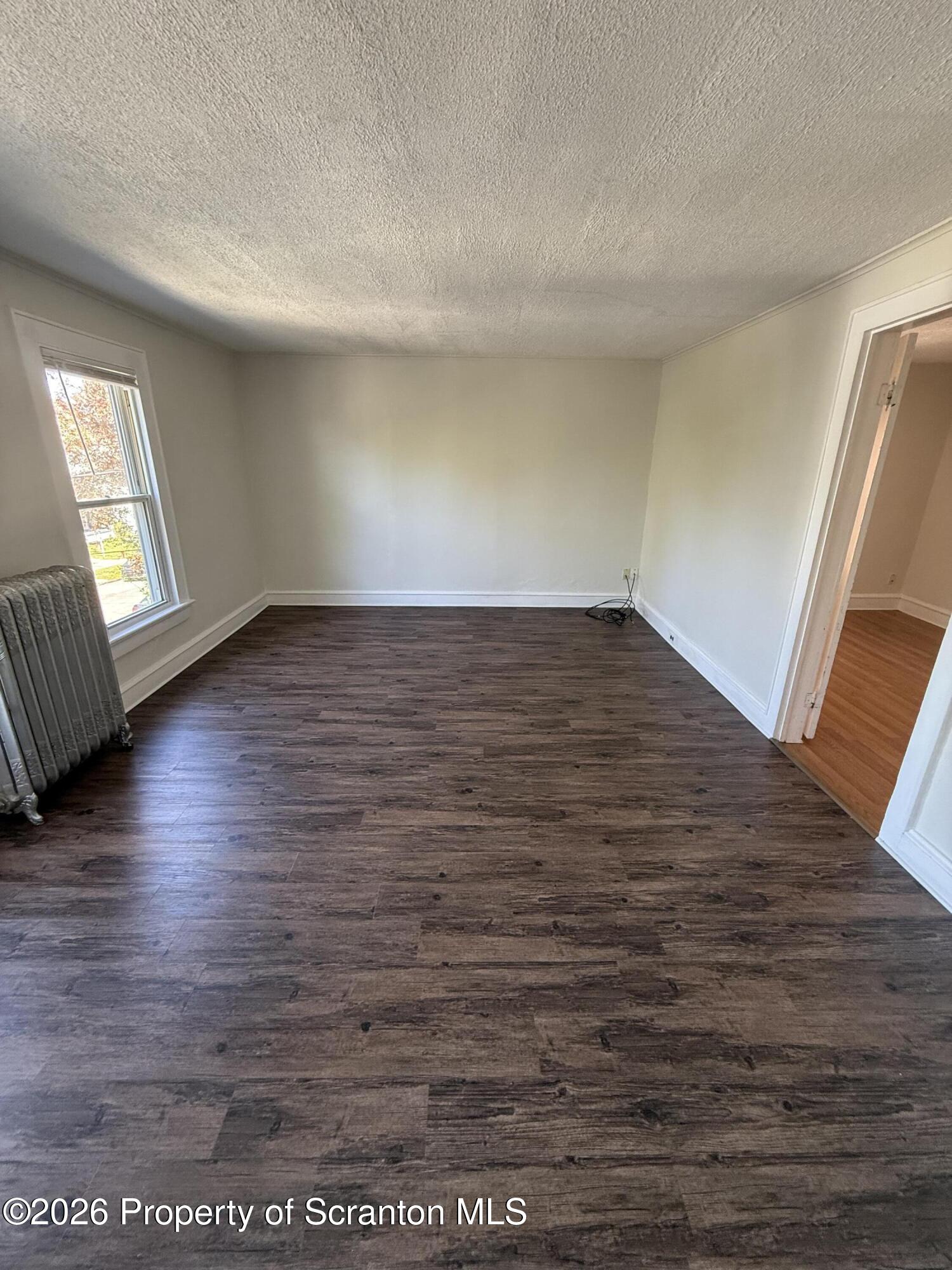 1042 Taylor Avenue, Unit 2 Scranton, PA 18510 - Photo 6 of 14 an empty room with wooden floor and windows