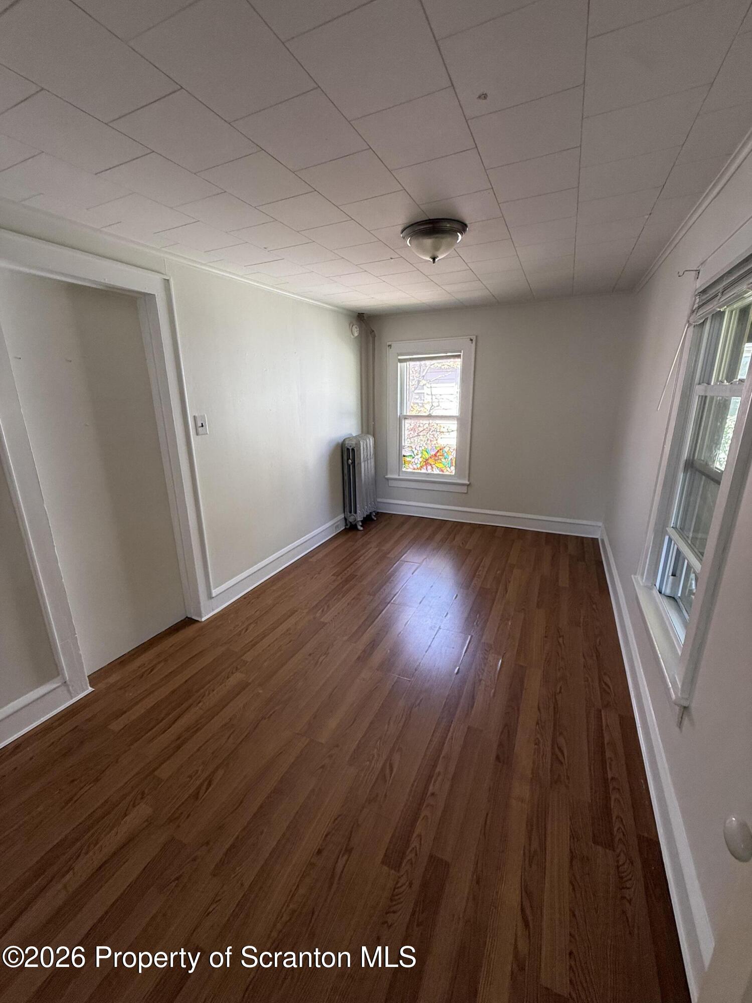 1042 Taylor Avenue, Unit 2 Scranton, PA 18510 - Photo 9 of 14 an empty room with wooden floor and windows