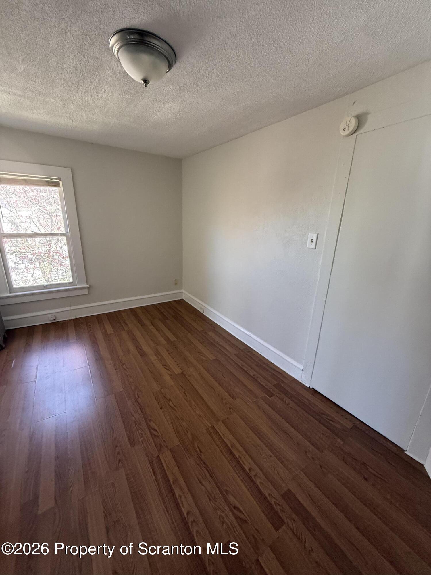 1042 Taylor Avenue, Unit 2 Scranton, PA 18510 - Photo 10 of 14 an empty room with wooden floor and windows