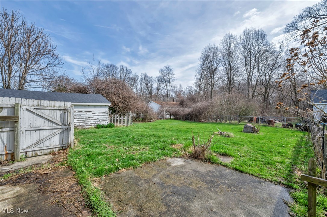 View of yard featuring an outbuilding, a patio area, and fence
