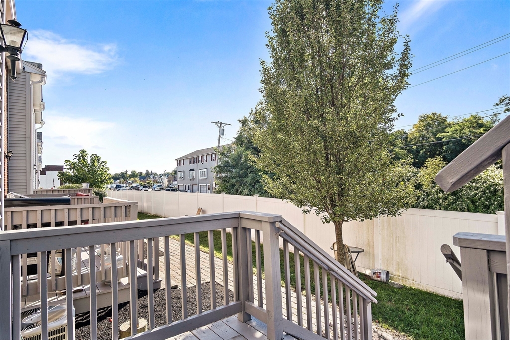 30 Angle Street, Unit 1 Lowell, MA 01851 - Photo 17 of 20 a balcony with wooden floor and fence