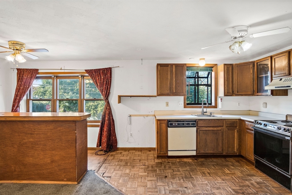 30 Angle Street, Unit 1 Lowell, MA 01851 - Photo 6 of 20 a kitchen with stainless steel appliances granite countertop a stove a sink and a microwave