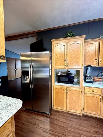 a kitchen with stainless steel appliances a stove a refrigerator a sink and white cabinets with wooden floor