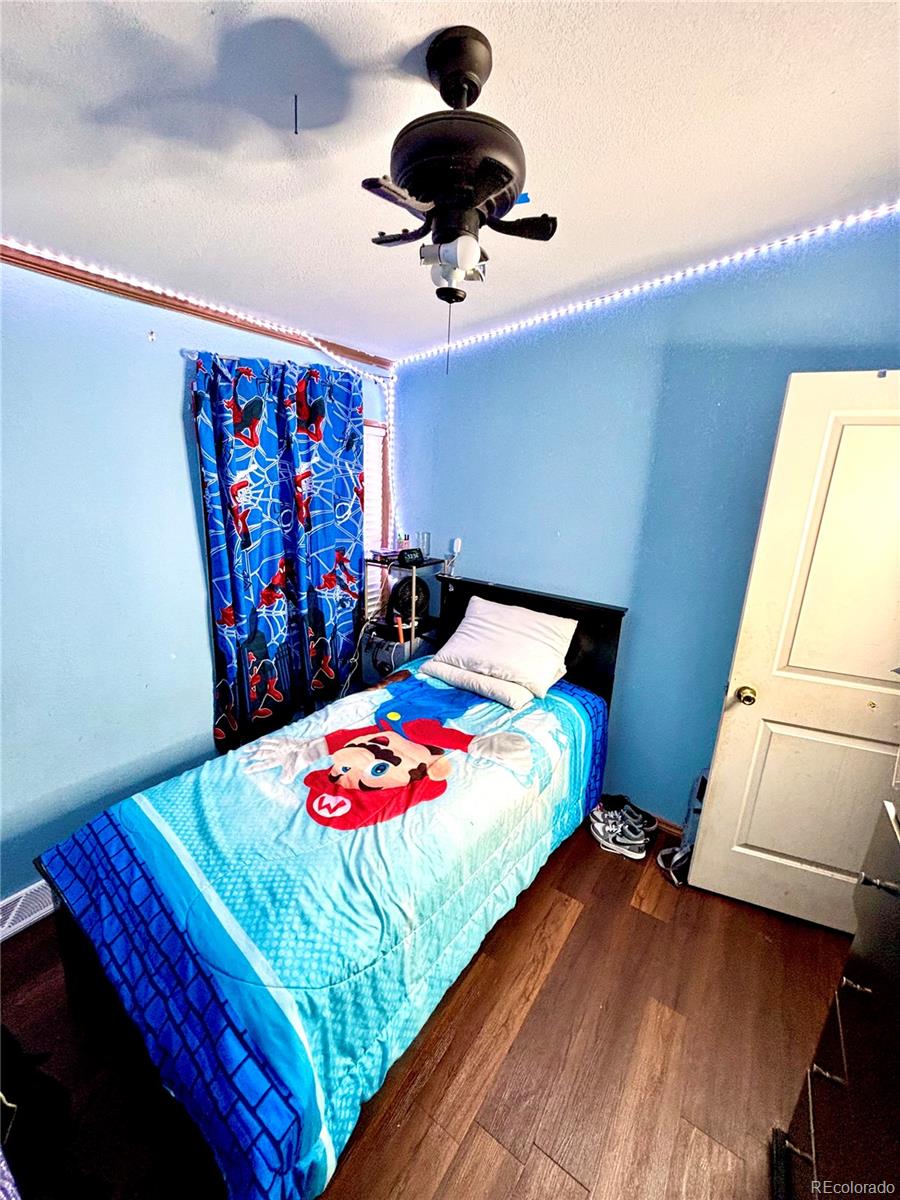 2660 Hawk Street Denver, CO 80260 - Photo 20 of 25 a bedroom with a bed and a painting on the wall