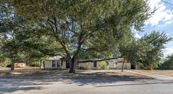 a front view of a house with a tree