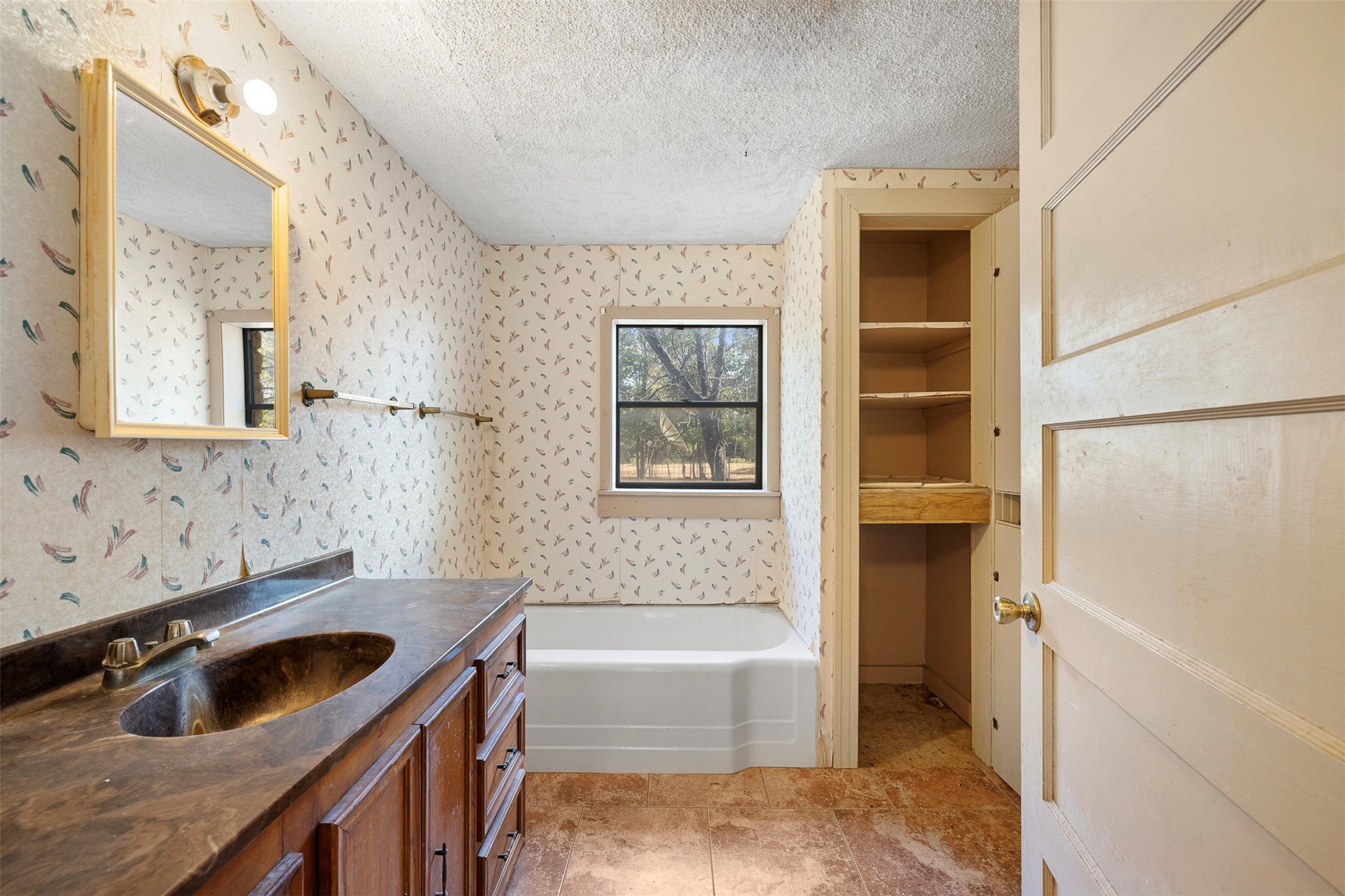 517 First Street Lexington, TX 78947 - Photo 14 of 37 a bathroom with a tub sink and mirror
