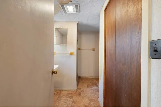 a backyard of a house with large trees and a wooden fence