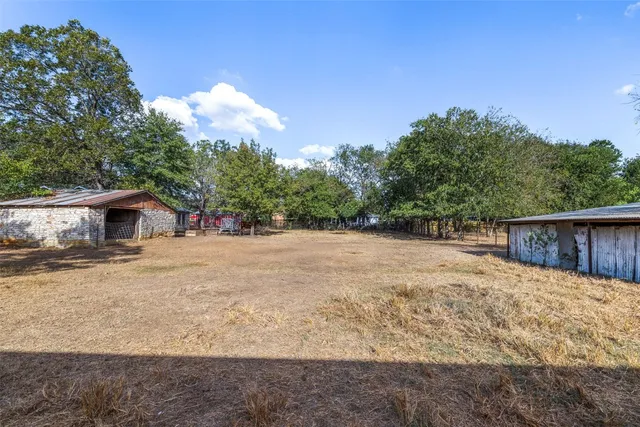 a view of a backyard with table and chairs and a barbeque