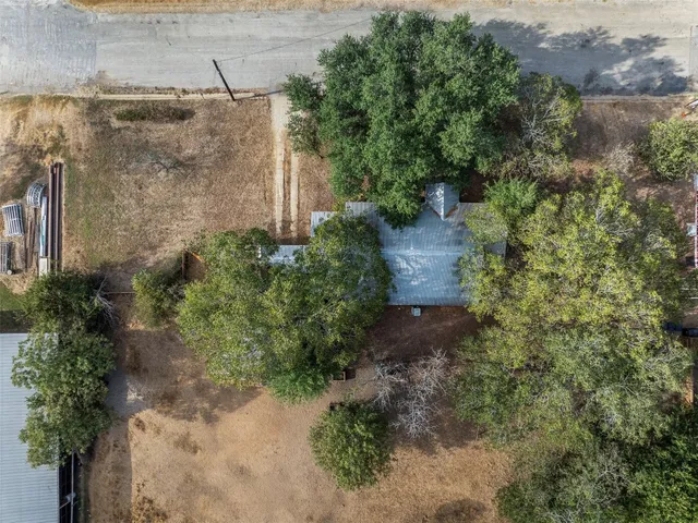 an aerial view of residential house with outdoor space and trees all around