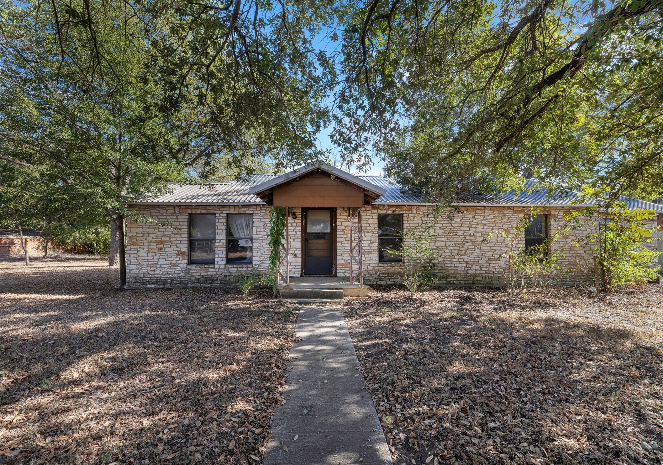 517 First Street Lexington, TX 78947 - Photo 3 of 37 a front view of a house with a garden and trees