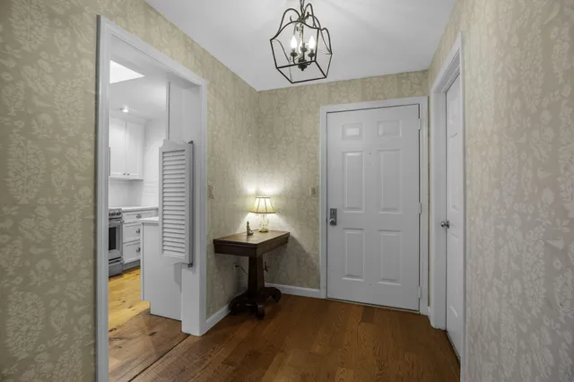 a view of a dining room with furniture a chandelier and wooden floor