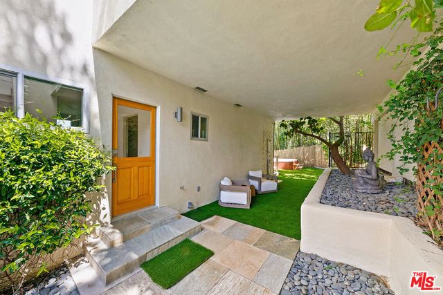 a view of a patio with couches table and chairs and potted plants