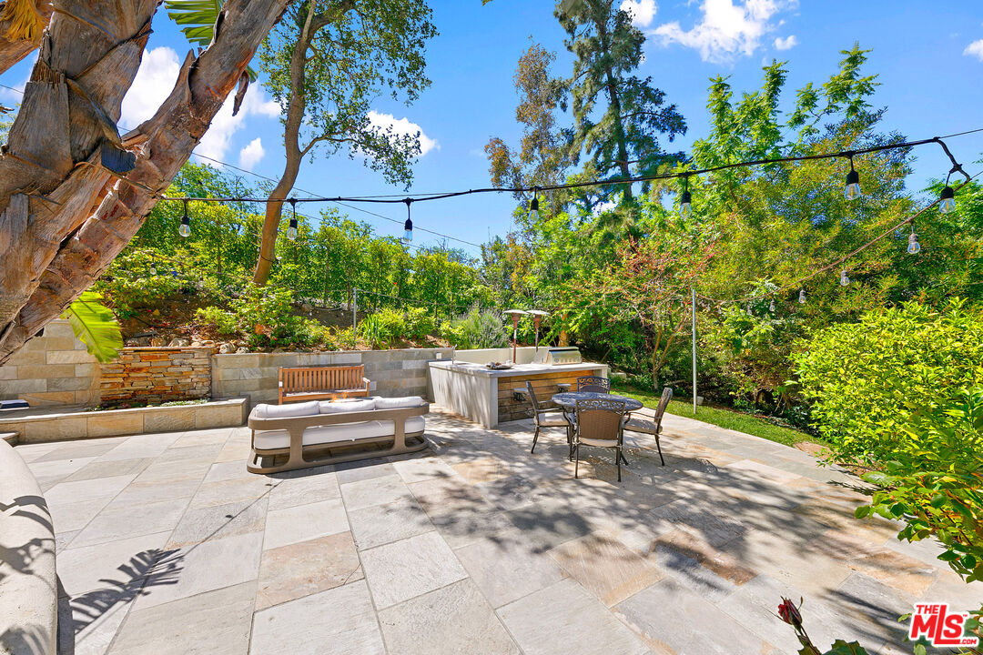 1876 Lookout Road Malibu, CA 90265 - Photo 33 of 44 a view of a patio with couches and table and chairs with potted plants