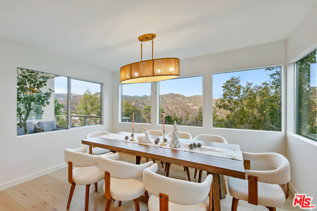 1876 Lookout Road Malibu, CA 90265 - Photo 4 of 44 a view of a dining room with furniture large windows and a chandelier
