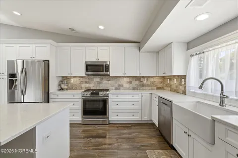 a kitchen with stainless steel appliances granite countertop a refrigerator sink and stove