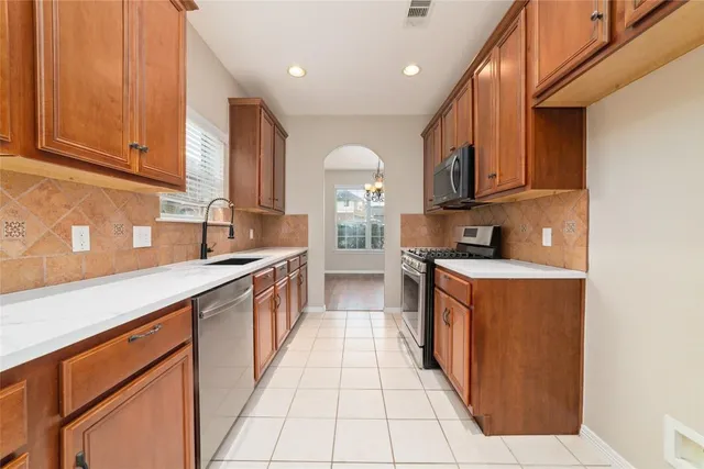 a large kitchen with stainless steel appliances granite countertop a stove a sink and a refrigerator