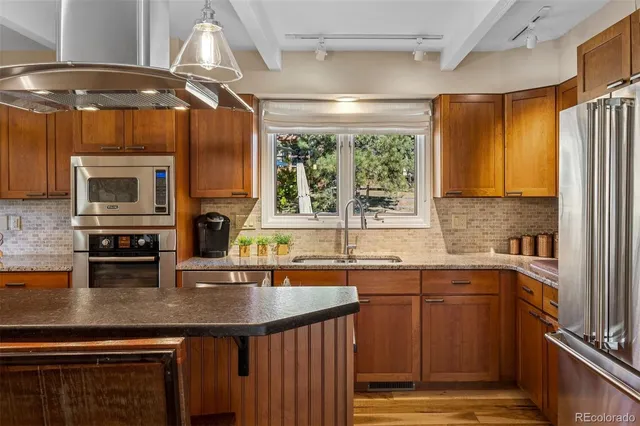 a kitchen with a sink a counter top space cabinets and stainless steel appliances