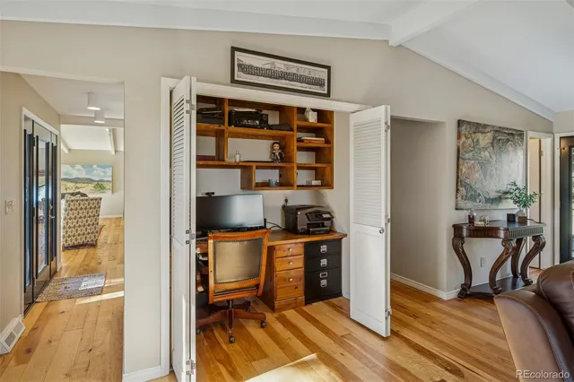 a view of a workspace with furniture and wooden floor