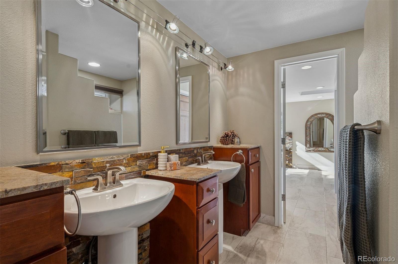 32329 Inverness Drive Evergreen, CO 80439 - Photo 24 of 48 a bathroom with a sink and a mirror