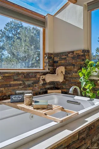 a kitchen sink with granite countertop a bunch of windows in it