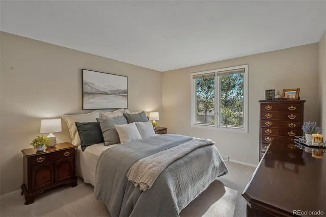 a bedroom with a bed and a flat tv screen on a dresser