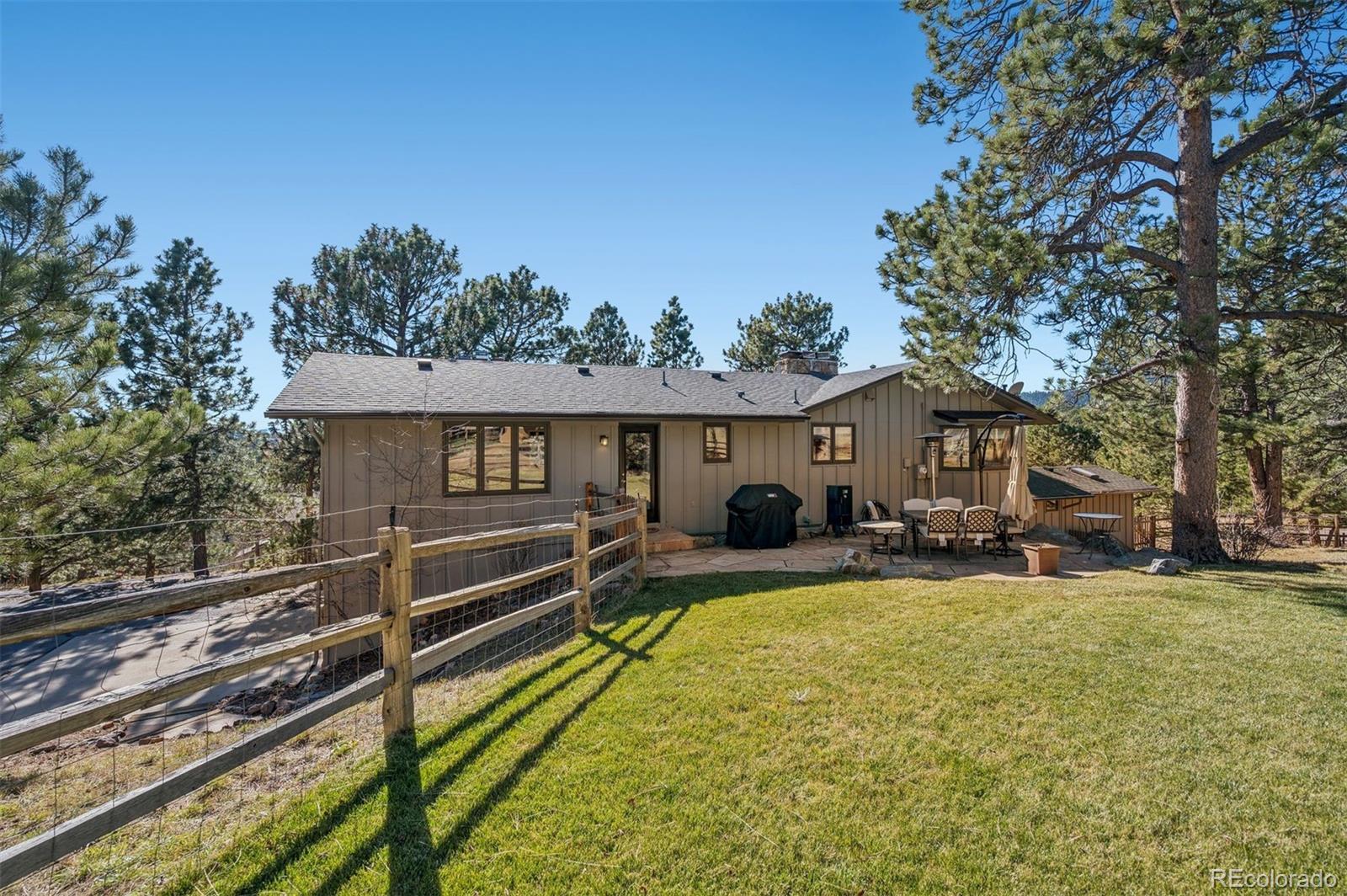 32329 Inverness Drive Evergreen, CO 80439 - Photo 34 of 48 a view of a house with a yard chairs and a table