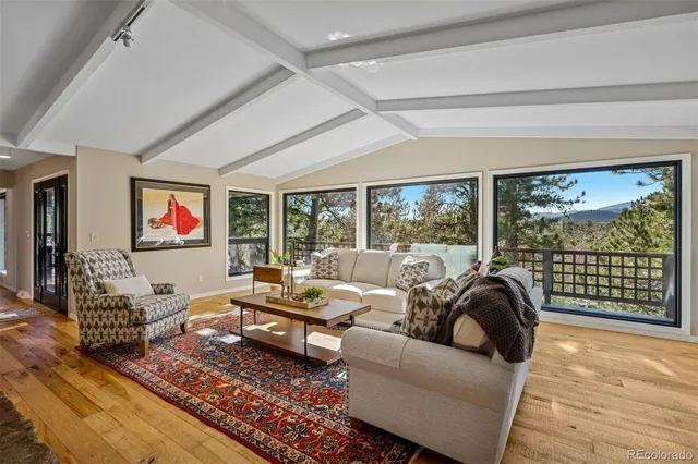 a living room with furniture large window and flat screen tv