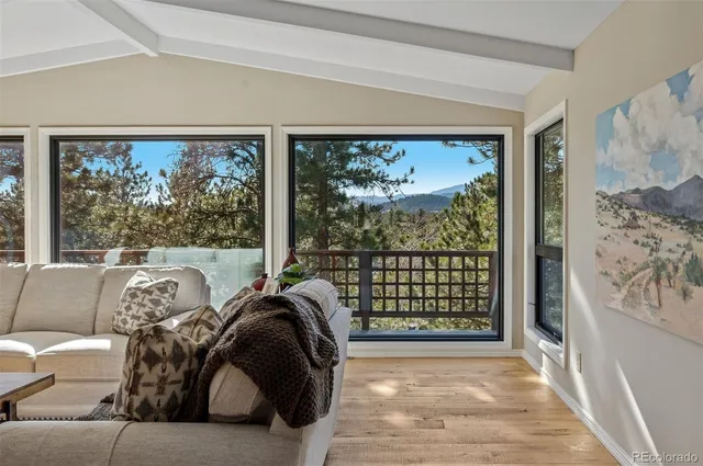 a living room with couch floor to ceiling window and floor to ceiling window