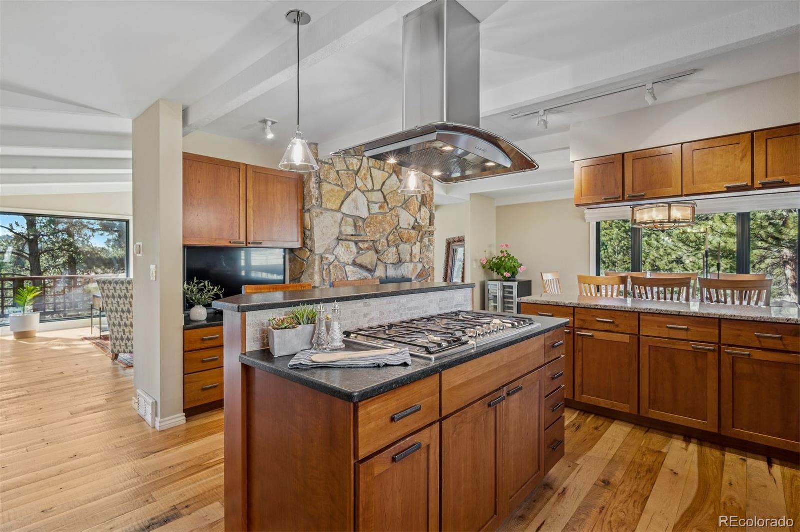 32329 Inverness Drive Evergreen, CO 80439 - Photo 9 of 48 a kitchen with stainless steel appliances granite countertop a stove and a wooden floors