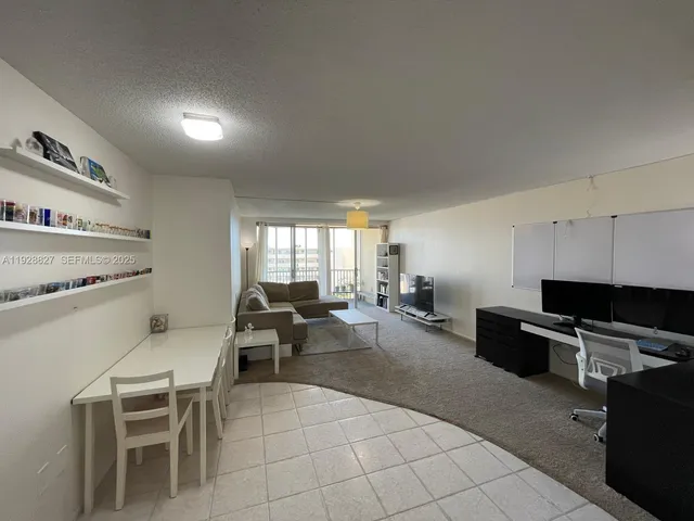 a living room with furniture a flat screen tv and a window