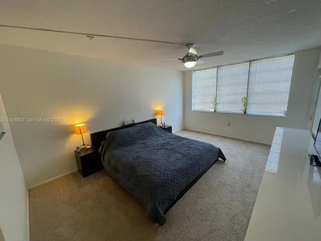 a bed sitting in a room next to a lamp