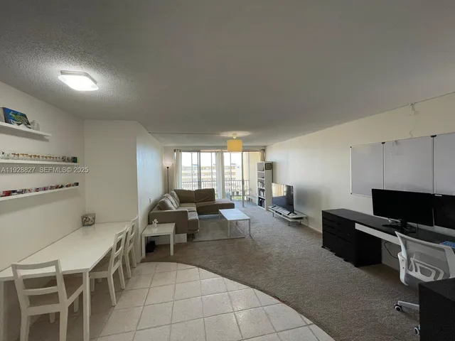 a living room with furniture a flat screen tv and a window