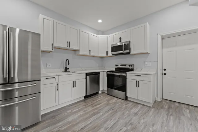 a kitchen with granite countertop a stove a sink and a microwave