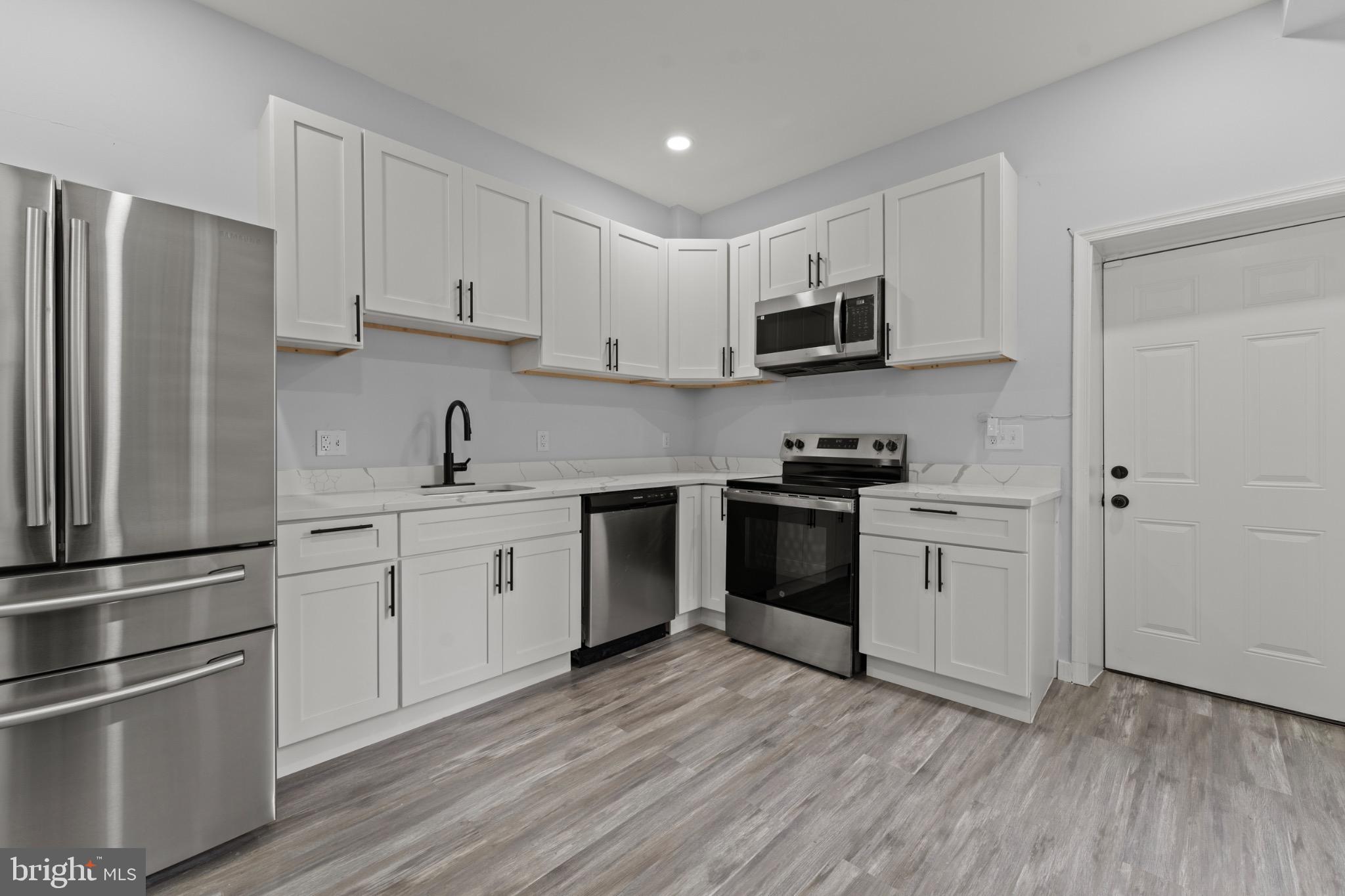 917 Edmondson Avenue Baltimore, MD 21223 - Photo 12 of 27 a kitchen with granite countertop white cabinets and stainless steel appliances