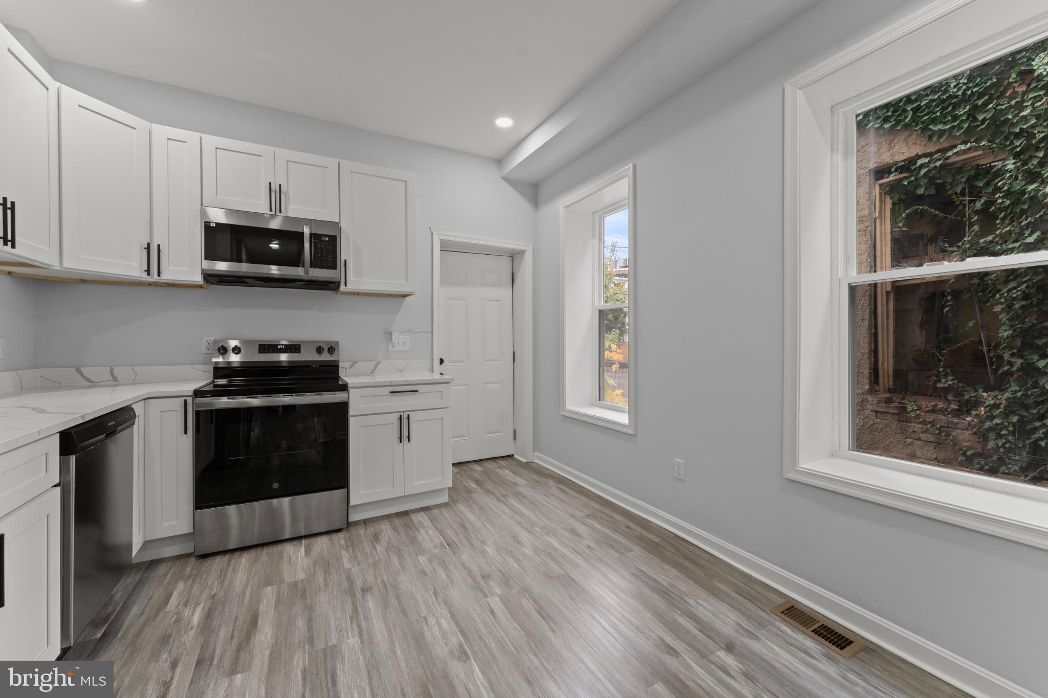 917 Edmondson Avenue Baltimore, MD 21223 - Photo 13 of 27 a kitchen with granite countertop a stove a sink and a microwave