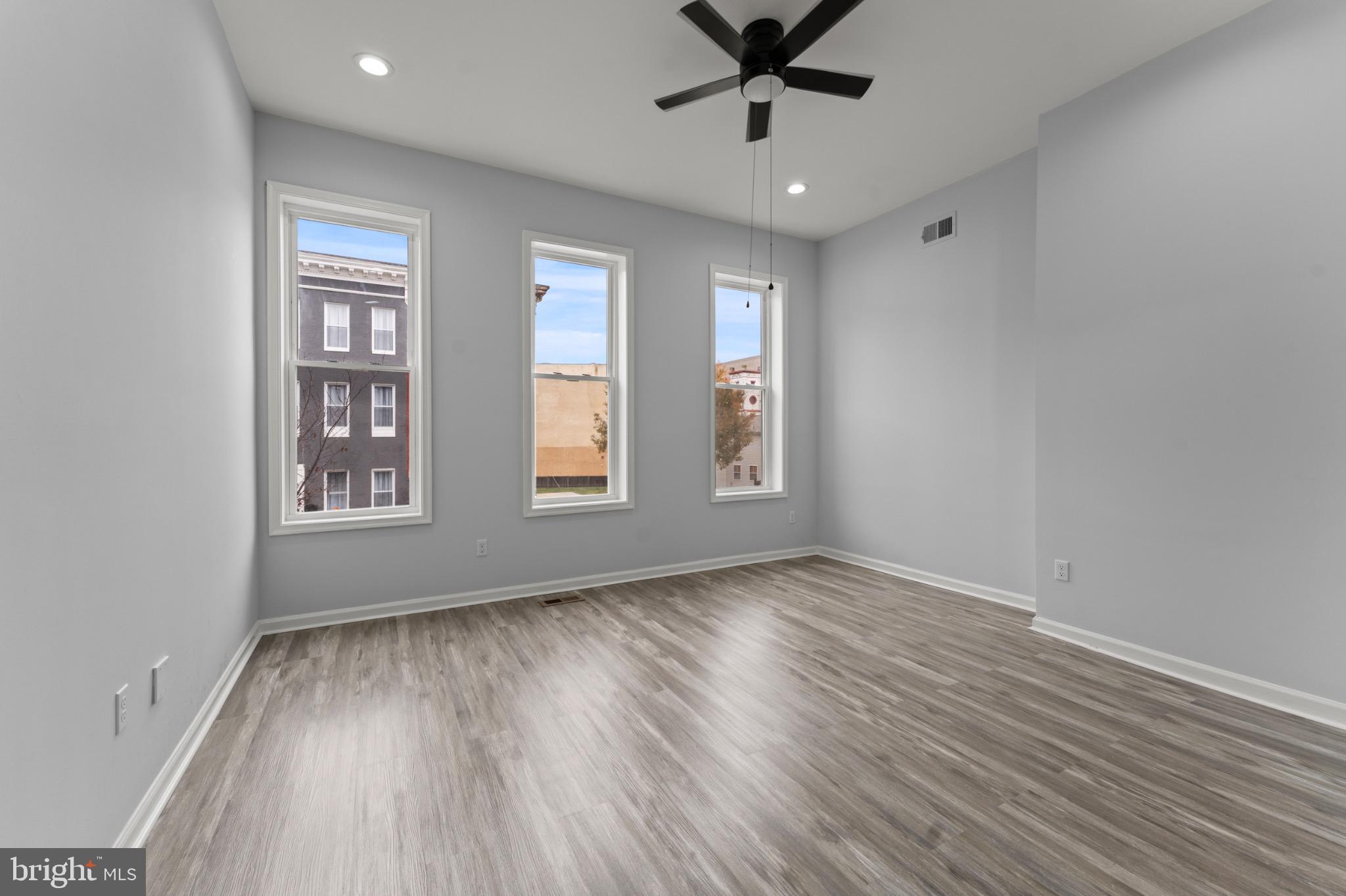 917 Edmondson Avenue Baltimore, MD 21223 - Photo 19 of 27 a view of empty room with wooden floor and fan