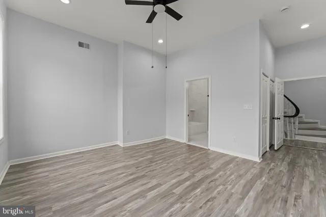 wooden floor in an empty room with a ceiling fan