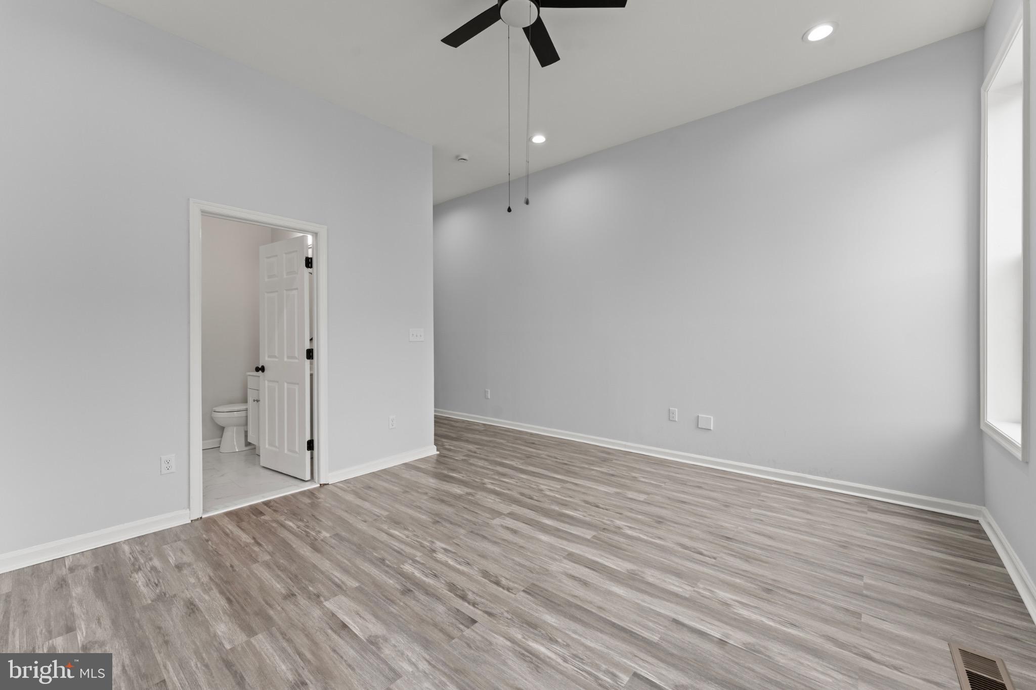 917 Edmondson Avenue Baltimore, MD 21223 - Photo 21 of 27 wooden floor in an empty room with a ceiling fan