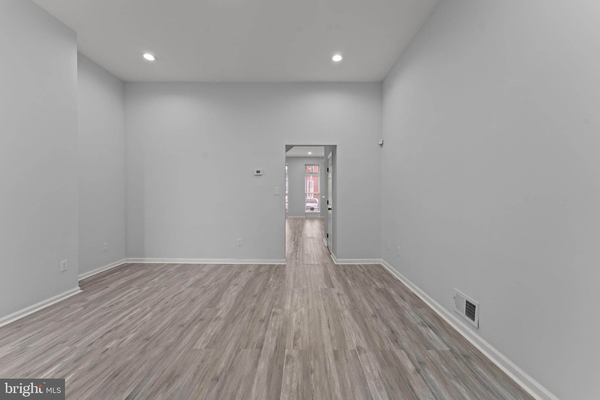 917 Edmondson Avenue Baltimore, MD 21223 - Photo 8 of 27 an empty room with wooden floor and windows