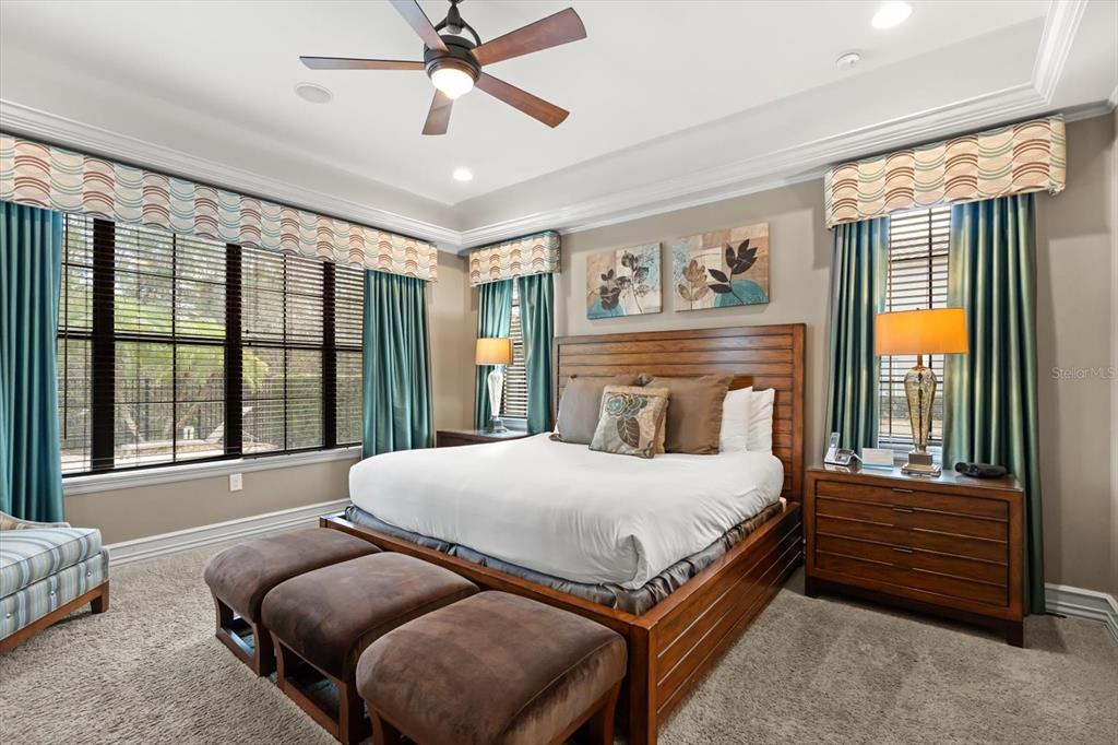 1105 Watson Court Reunion, FL 34747 - Photo 22 of 61 a bedroom with a large bed and a chandelier fan