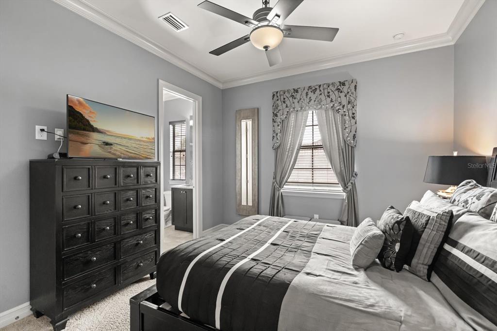 1105 Watson Court Reunion, FL 34747 - Photo 25 of 61 a bedroom with a bed a dresser and a chandelier