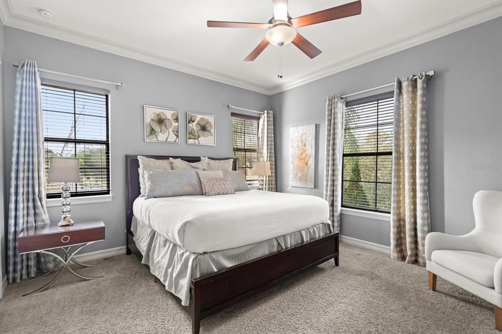 1105 Watson Court Reunion, FL 34747 - Photo 30 of 61 a spacious bedroom with a large bed and a chandelier