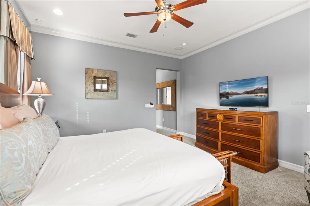 1105 Watson Court Reunion, FL 34747 - Photo 50 of 61 a bedroom with a bed and a chandelier