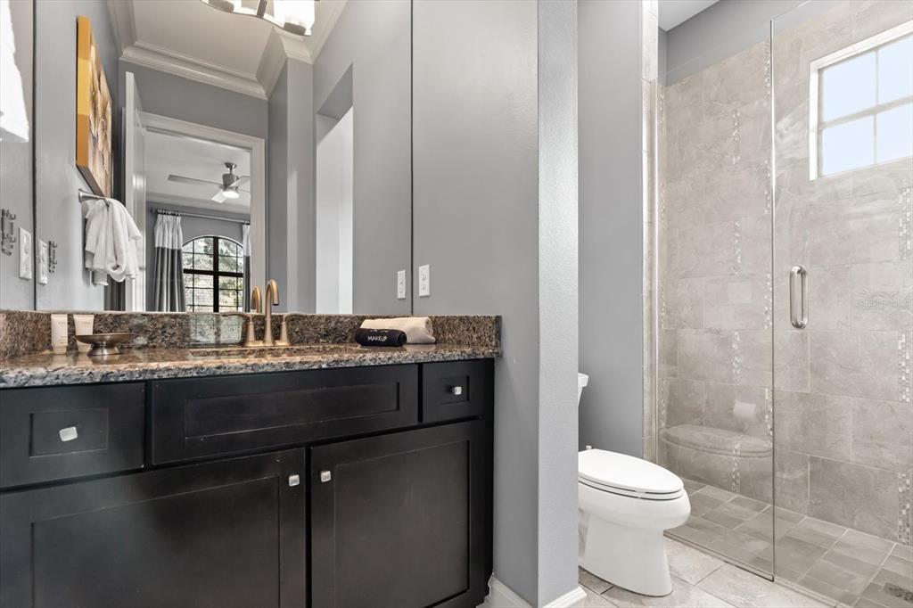 1105 Watson Court Reunion, FL 34747 - Photo 58 of 61 a bathroom with a granite countertop toilet sink and mirror