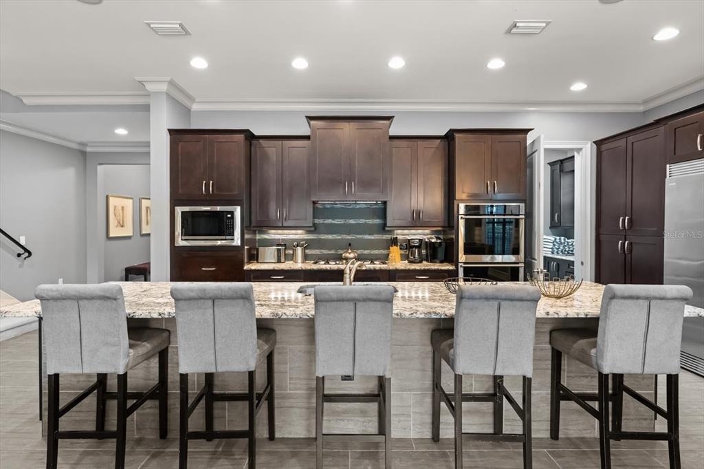 1105 Watson Court Reunion, FL 34747 - Photo 10 of 61 a large kitchen with a table chairs refrigerator and microwave