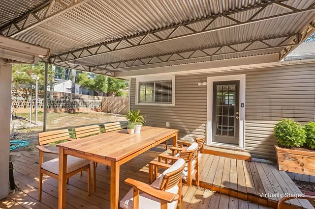 a view of a patio with table and chairs with wooden floor and fence